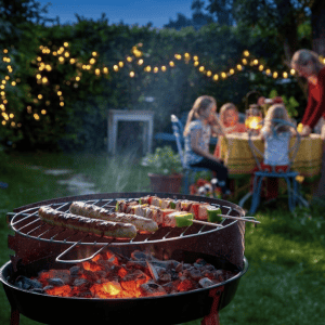Griglia accesa con salsicce e spiedini di carne per una festa in giardino a base di barbeque a Trento.